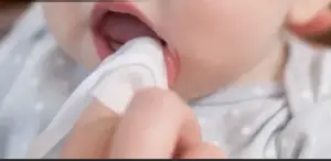 Cleaning baby gums with finger in How to know when your baby is teething n 