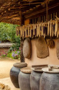 African kitchen surrounded by organic foods,cooking clay pots and vegetables farmland.