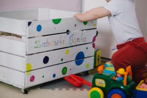 Toys lying around in baby's room / baby opening drawer.