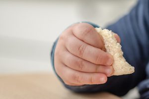 Baby holding food in hand.baby led weaning recipes