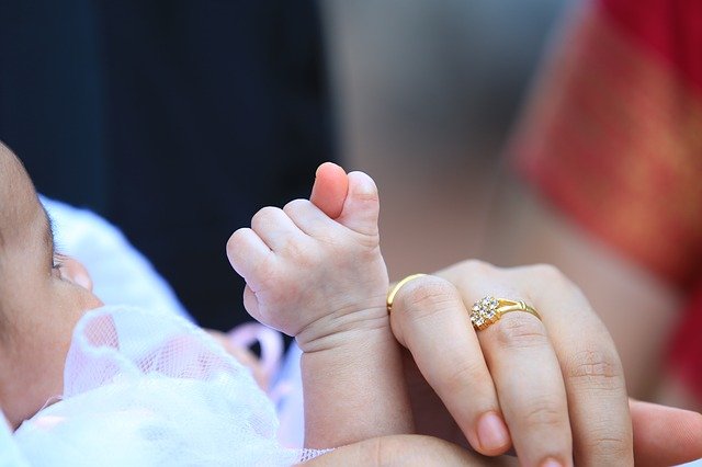 Mother massaging baby with castor oil for baby constipation.