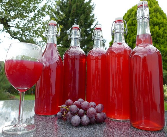 Grape juice for constipation in wine glass and in bottles