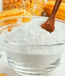 Cornstarch in a bowl with corn on a cob on the side ; in cornstarch for baby constipation.