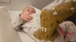 Baby with a massive diaper blowout in how to remove baby poop stains
