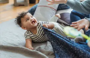 Angry baby pulling blanket to himself.