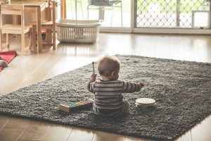 15 month old baby playing with wooden blocks in developmental red flags.in 15 Month Old Development Red Flags