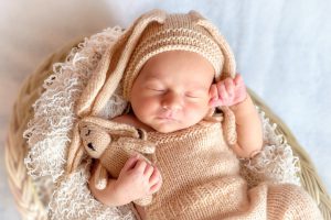 sleeping baby holding a toy bunny.