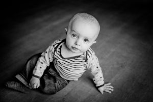 Bald baby sitting in baby hair growth stages.