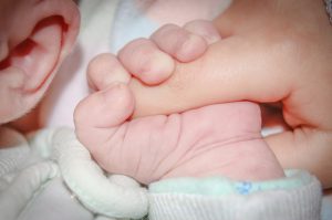 1 month old baby holding on to mother's finger