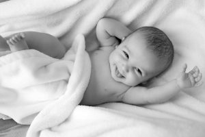 Newborn baby lying down smiling ; Best formula for gassy newborn