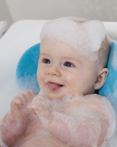 A bald headed baby taking a bath in how often to wash my baby's hair.