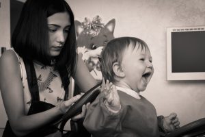 Mother giving a baby a hair cut; how to trim baby hair.