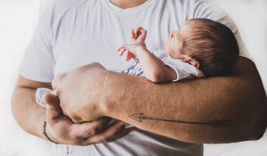 Father holding baby carefully in newborn belly button as stages.