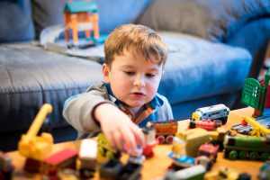 Toddler playing with lots of toys in his room